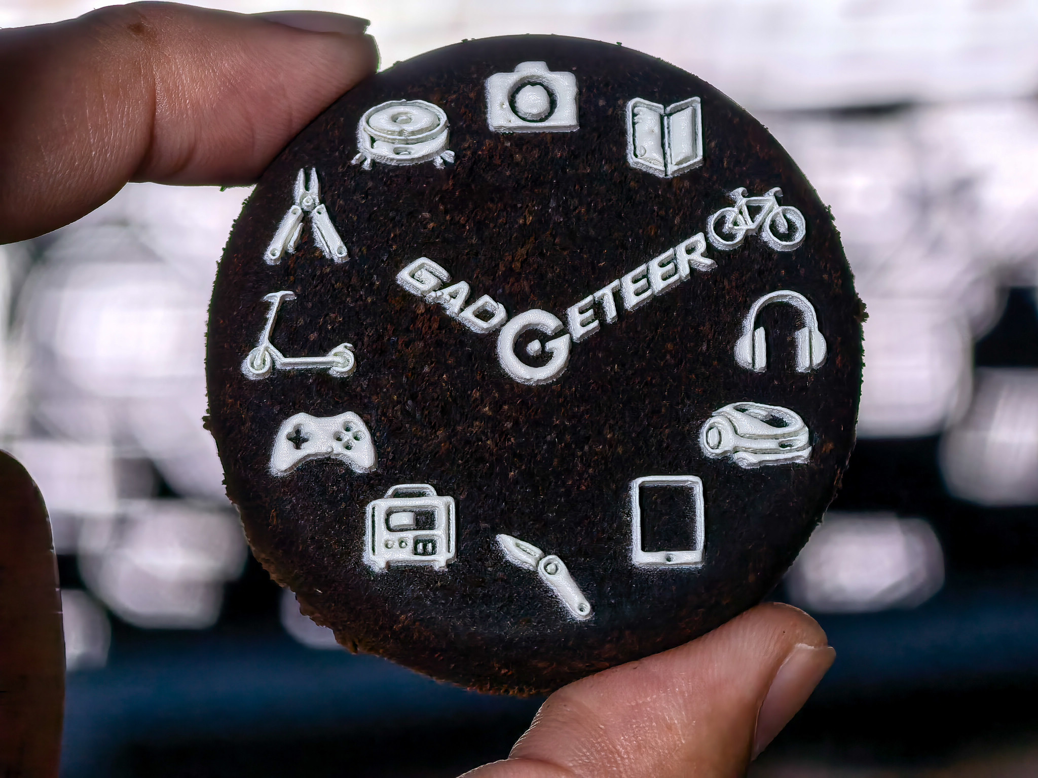 the Gadgeteer logo and gadget icons printed in white on an actual used espresso puck